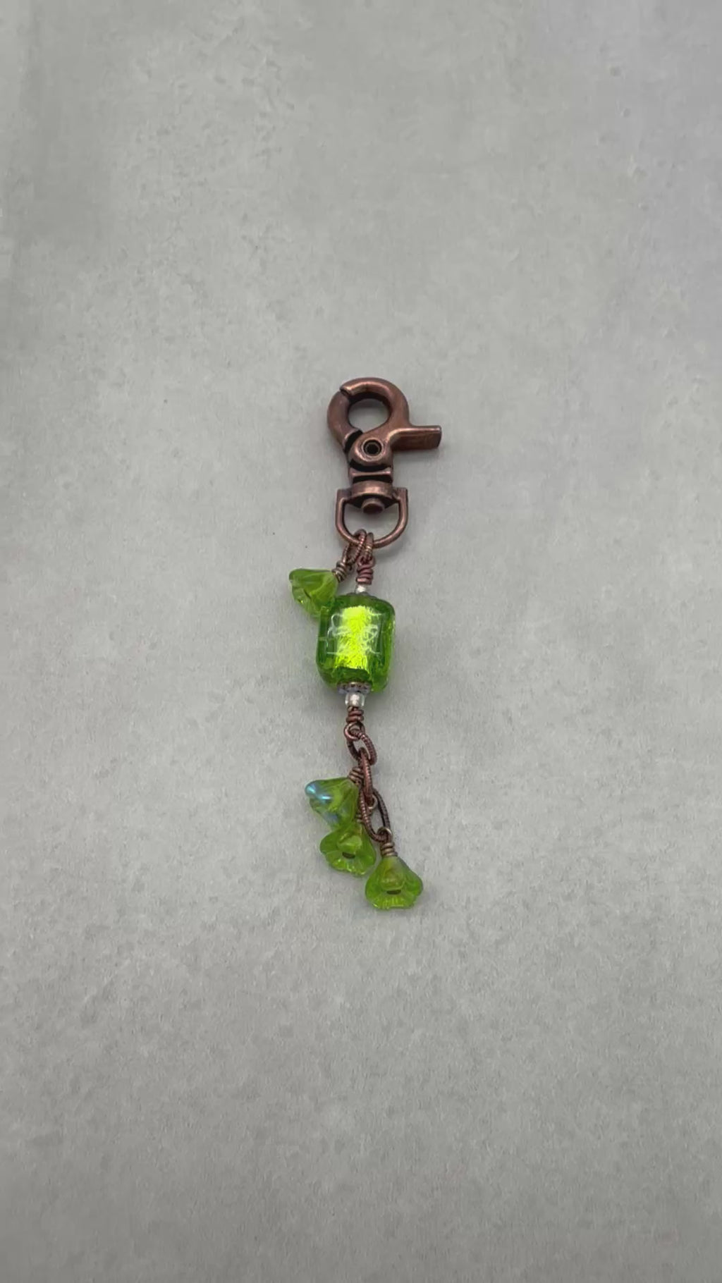 Video of a green keychain with a copper clasp