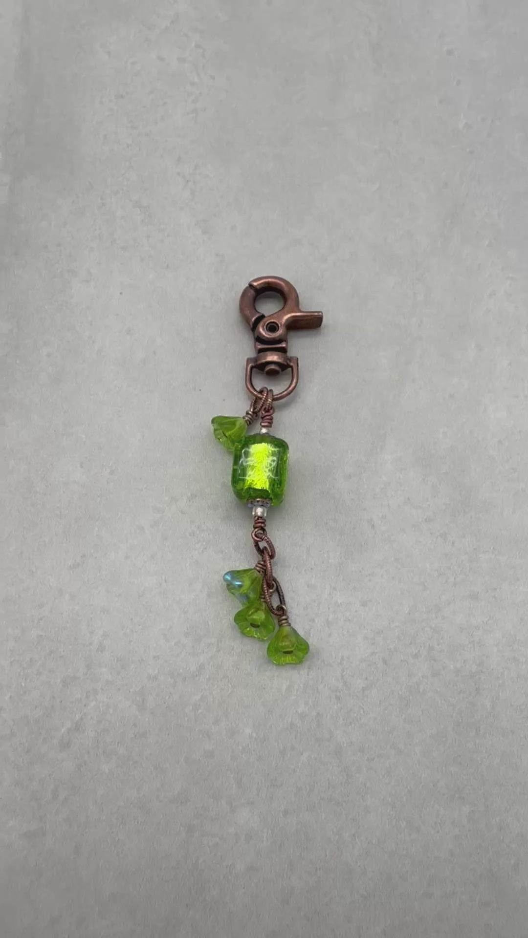 Video of a green keychain with a copper clasp