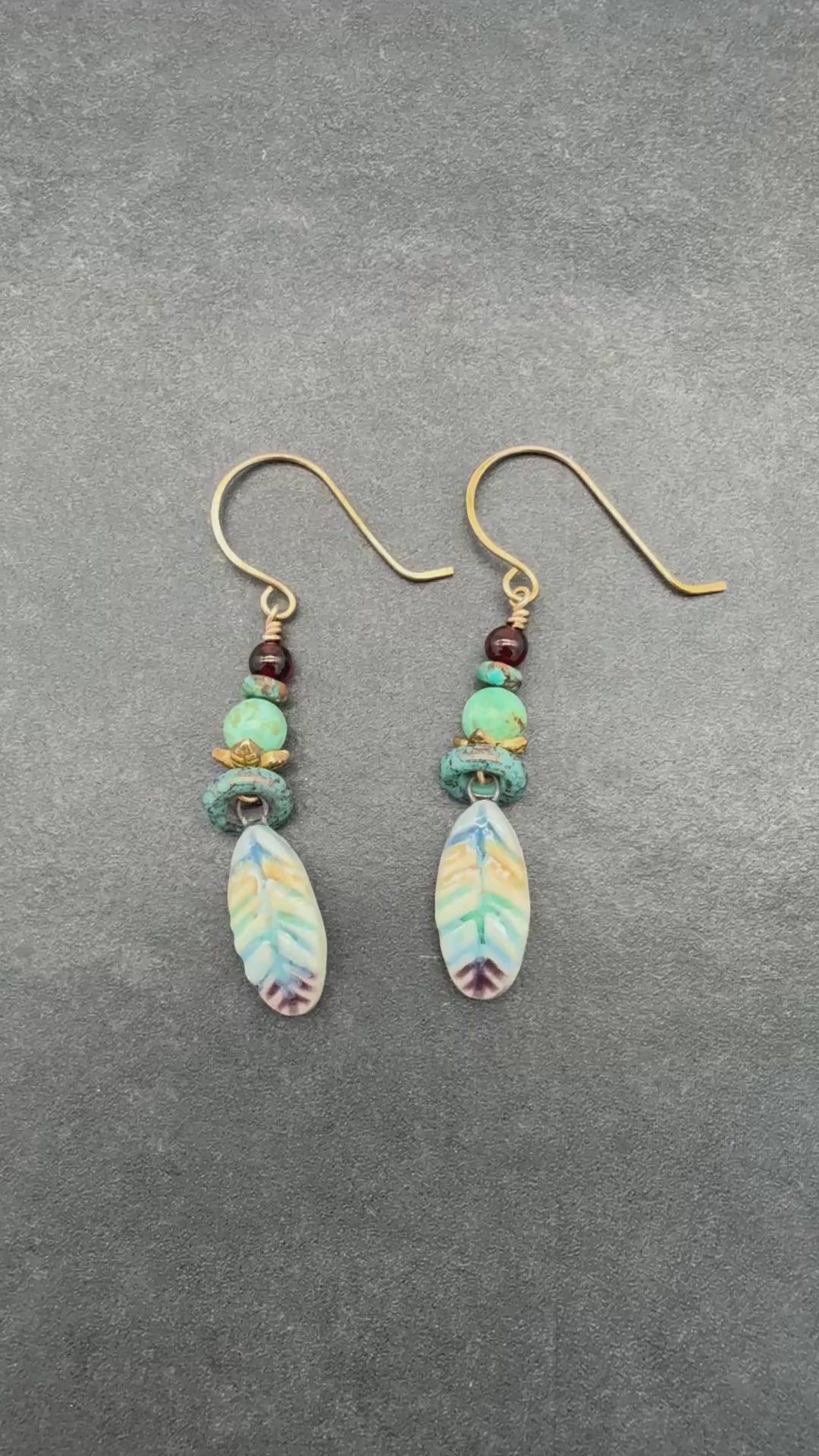 Video of earrings with turquoise and ceramic feathers