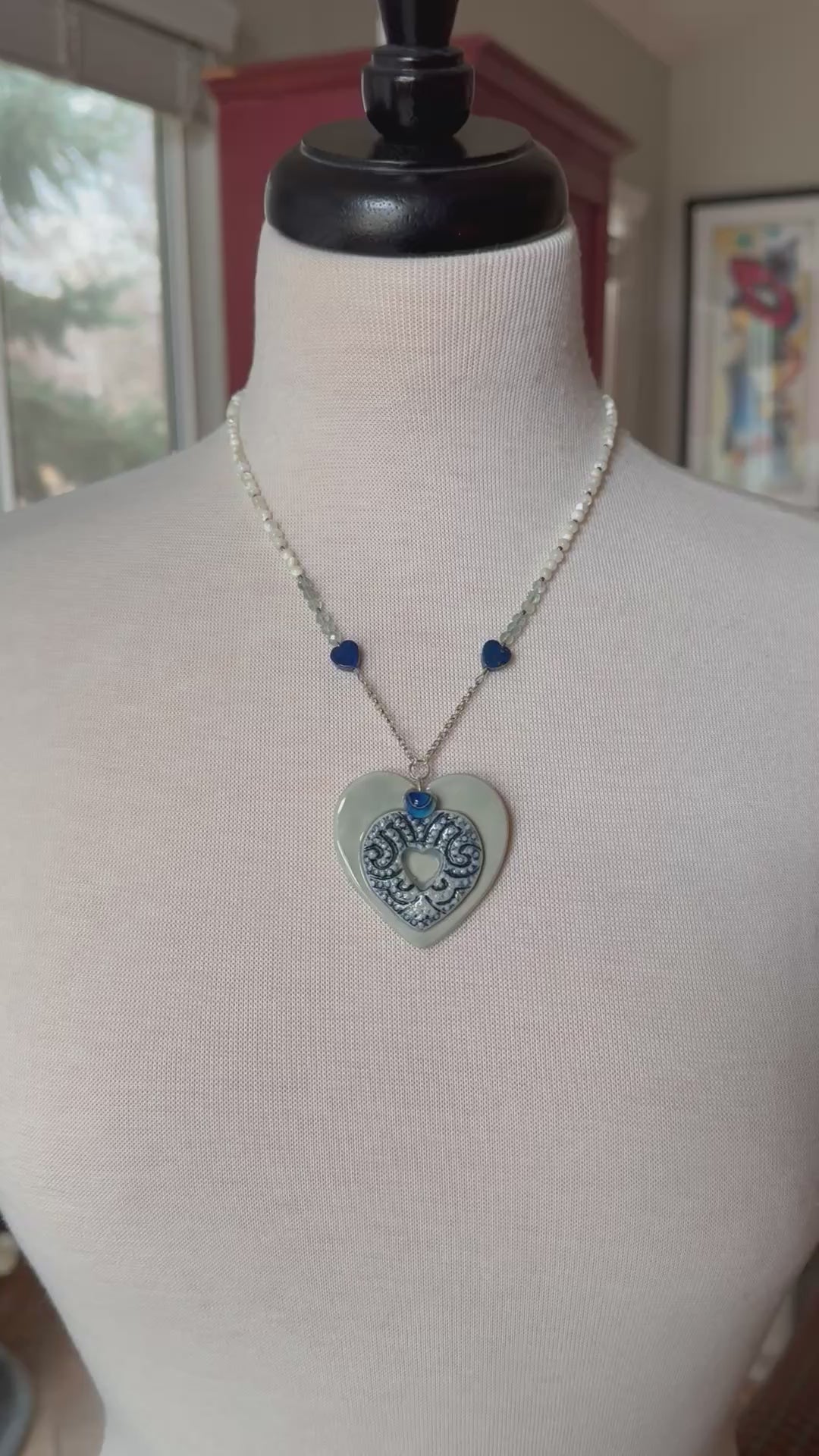 video of necklace with a heart shaped porcelain pendant on a mannequin