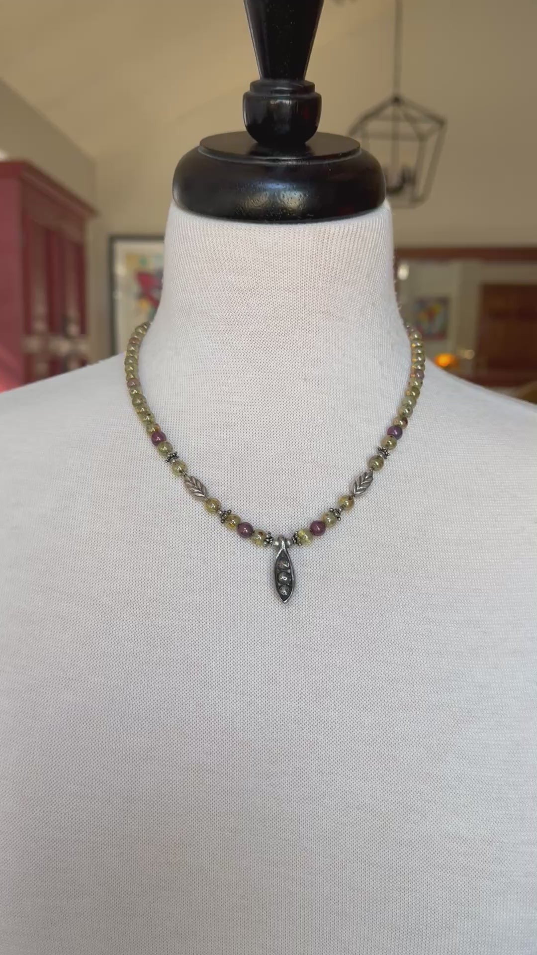 Video of colorful beaded necklace with a pewter peapod pendant on a mannequin