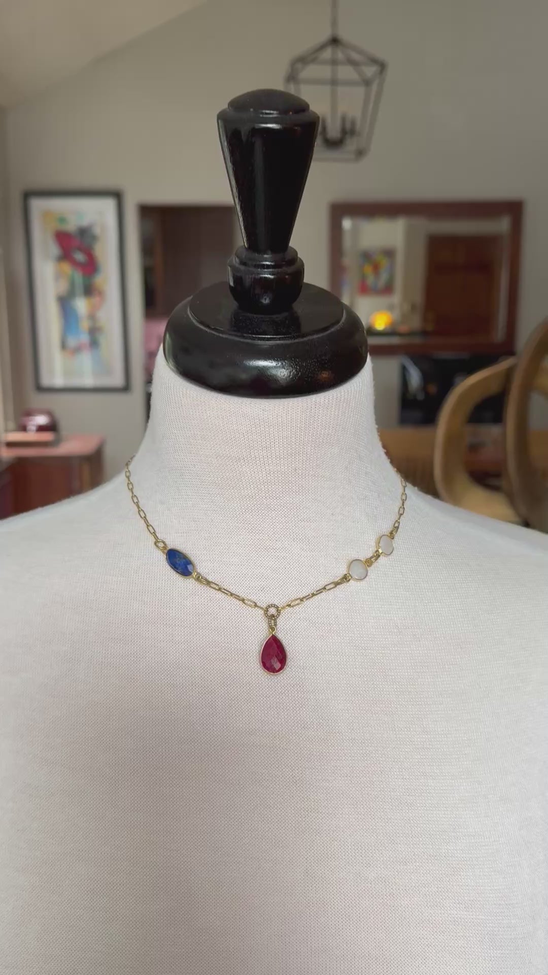 Video of a mannequin wearing a delicate gold chain choker necklace with a ruby pendant, lapis and rainbow moonstone links - art you can wear by Ruby Acorn