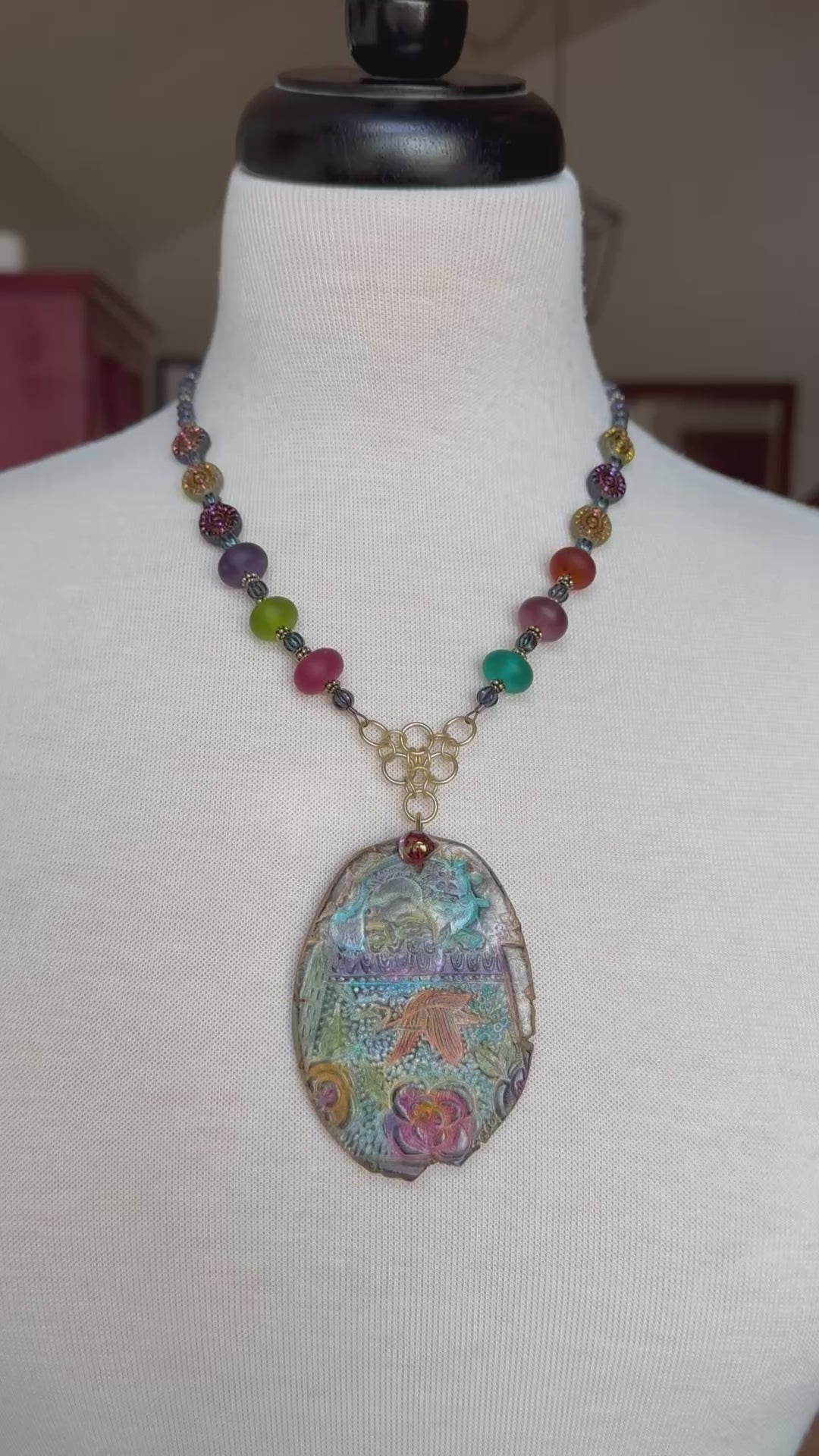 Video of colorful statement necklace with large decorative pendant on a mannequin 