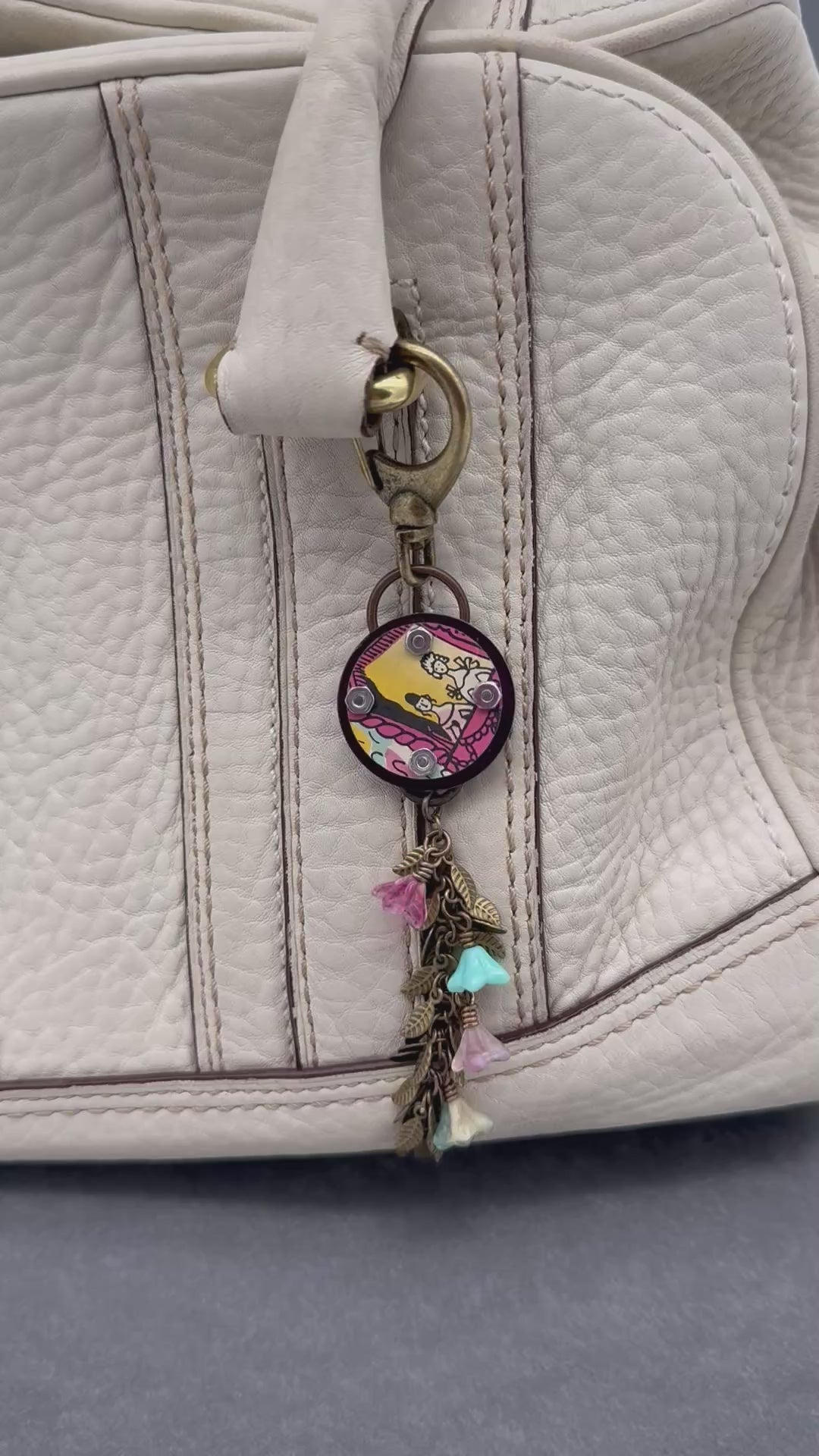 Video of decorative handbag charm displayed on a purse