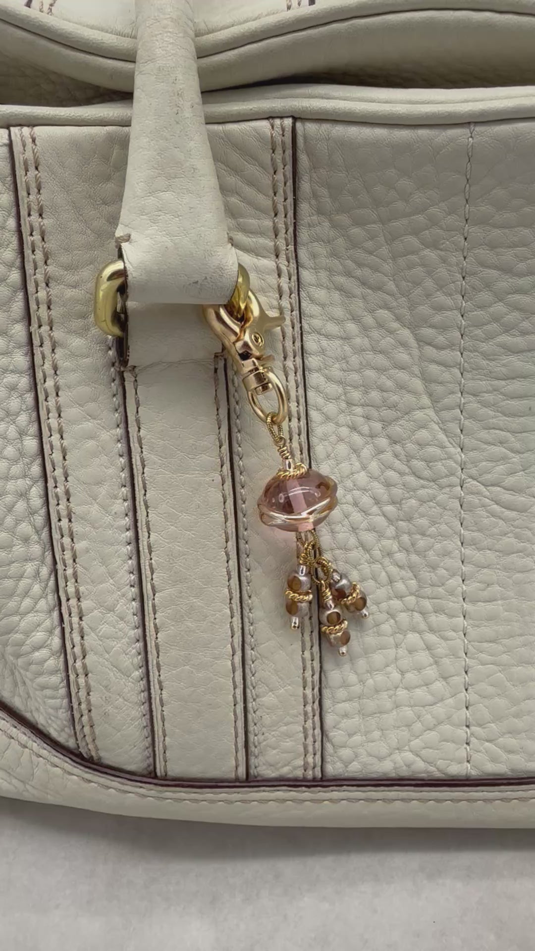 Video of gold clasp charm with pink and ivory beads