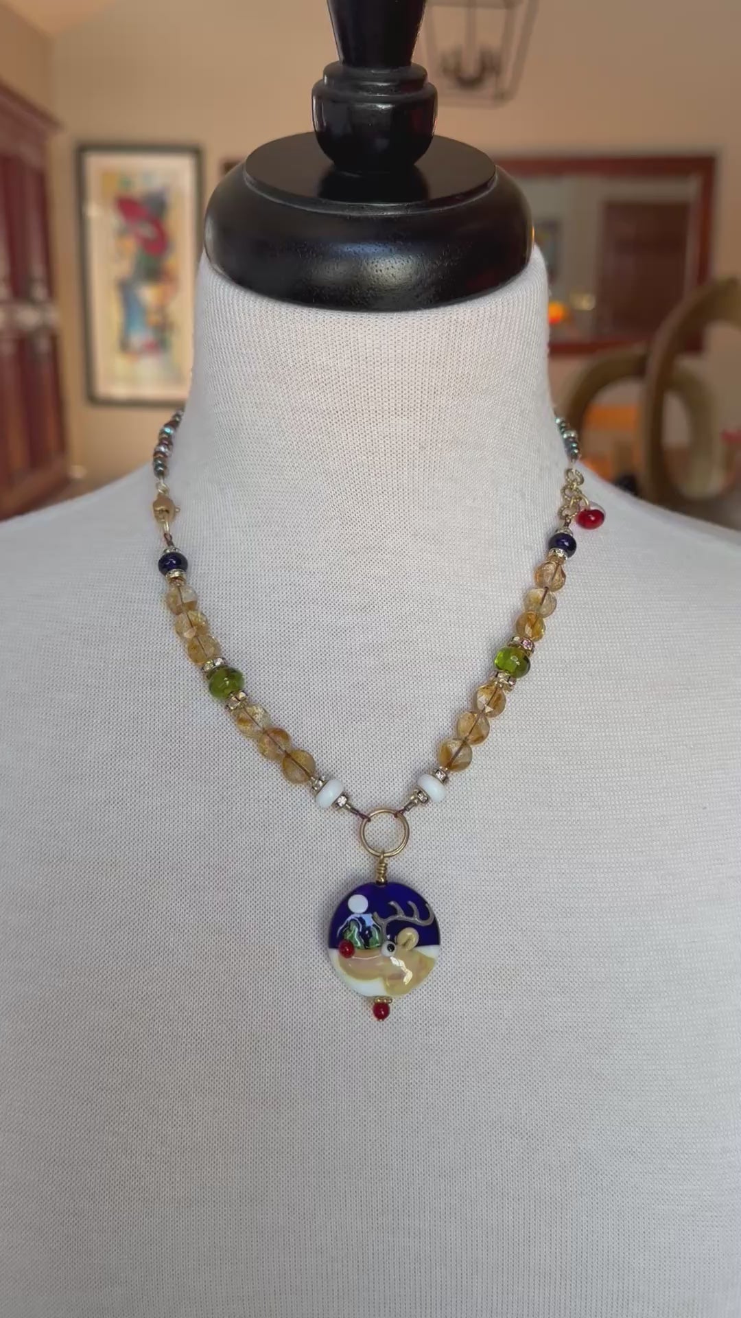 video of a festive necklace with a reindeer pendant on a mannequin