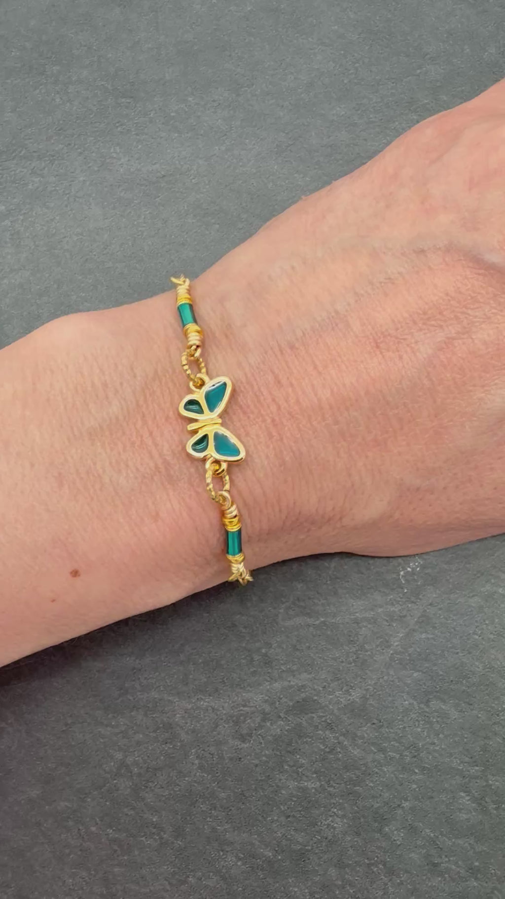 Video of a hand wearing a gold bracelet with a butterfly charm - art you can wear by Ruby Acorn